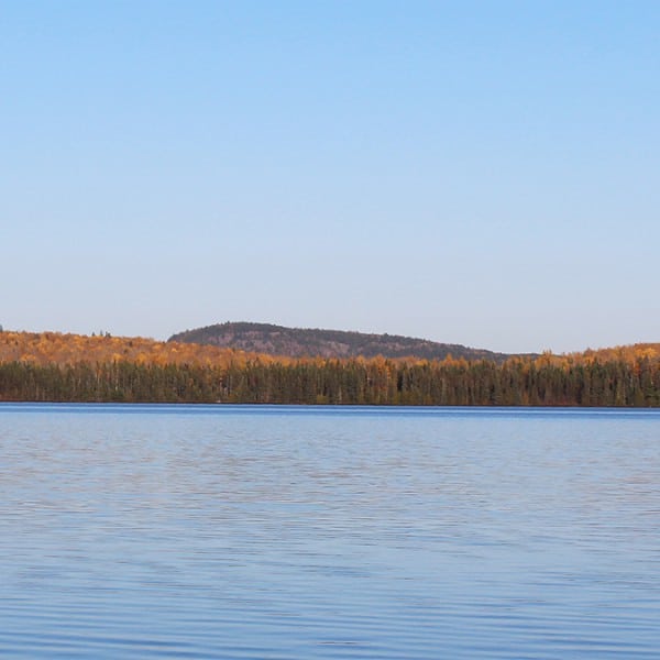 sawtooth mountain rising above inland lake and late season fall colors
