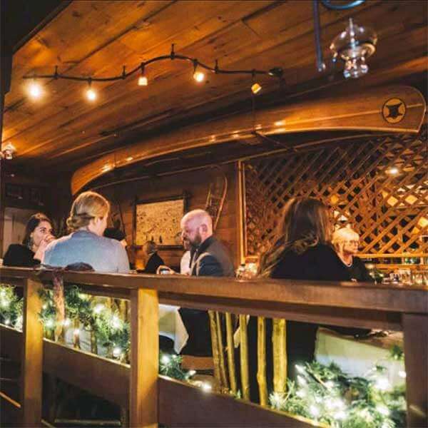 guests eat dinner in soft lit bearskin lodge dining room