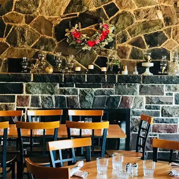 stone fireplace and tables at cascade restaurant overlooking lake superior