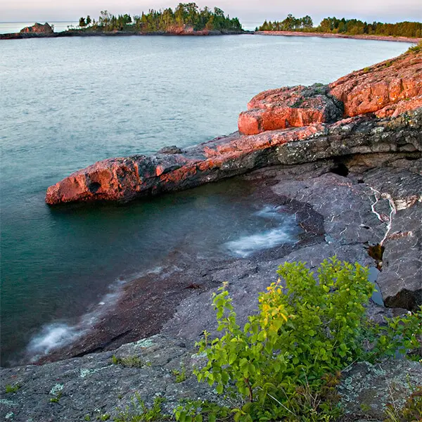 lichen covered billion year old lava flows entering sugarloaf cove north shore lake superior