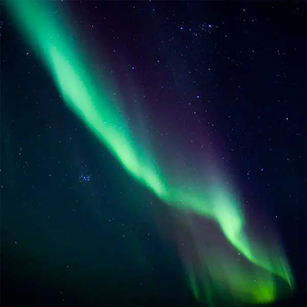 green and purple northern lights over the north shore