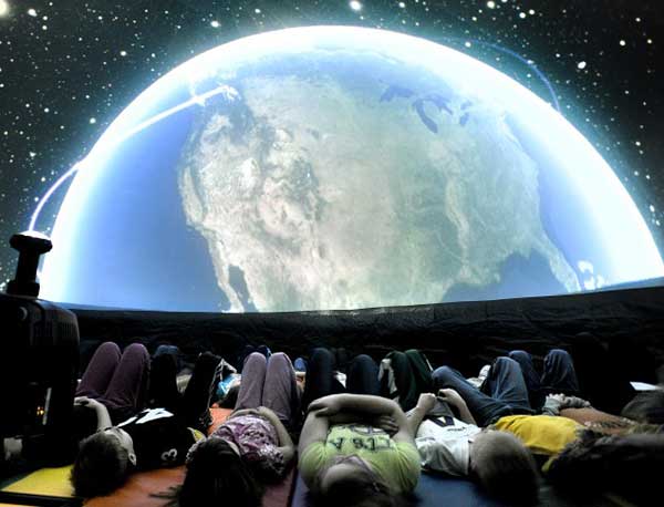 people lying on their backs at planetarium