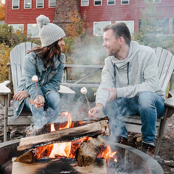 couple roasting marhsmallows on beach at lutsen resort on lake superior