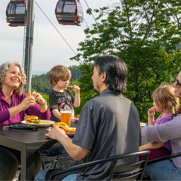family having dinner with lutsen gondola behind