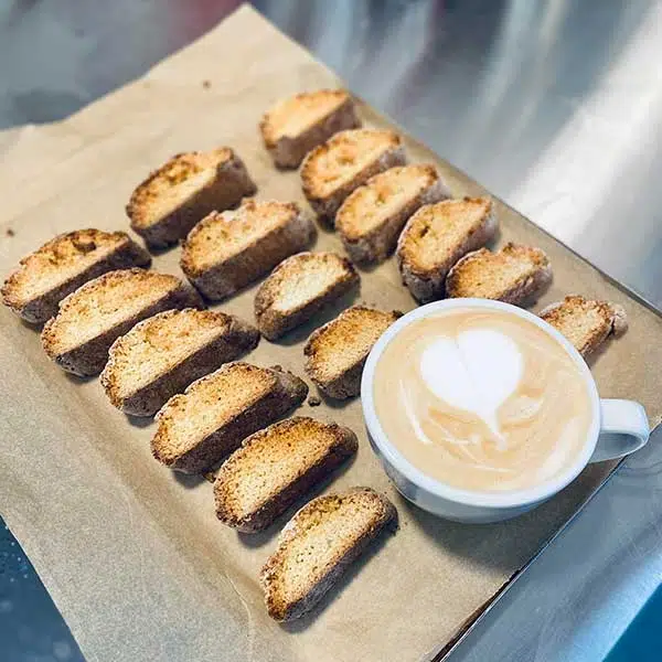 biscotti lined up with latte with heart in foam