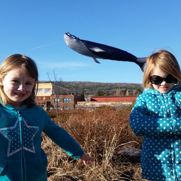 two girls in polka dot turquoise don't realize a whale is passing by