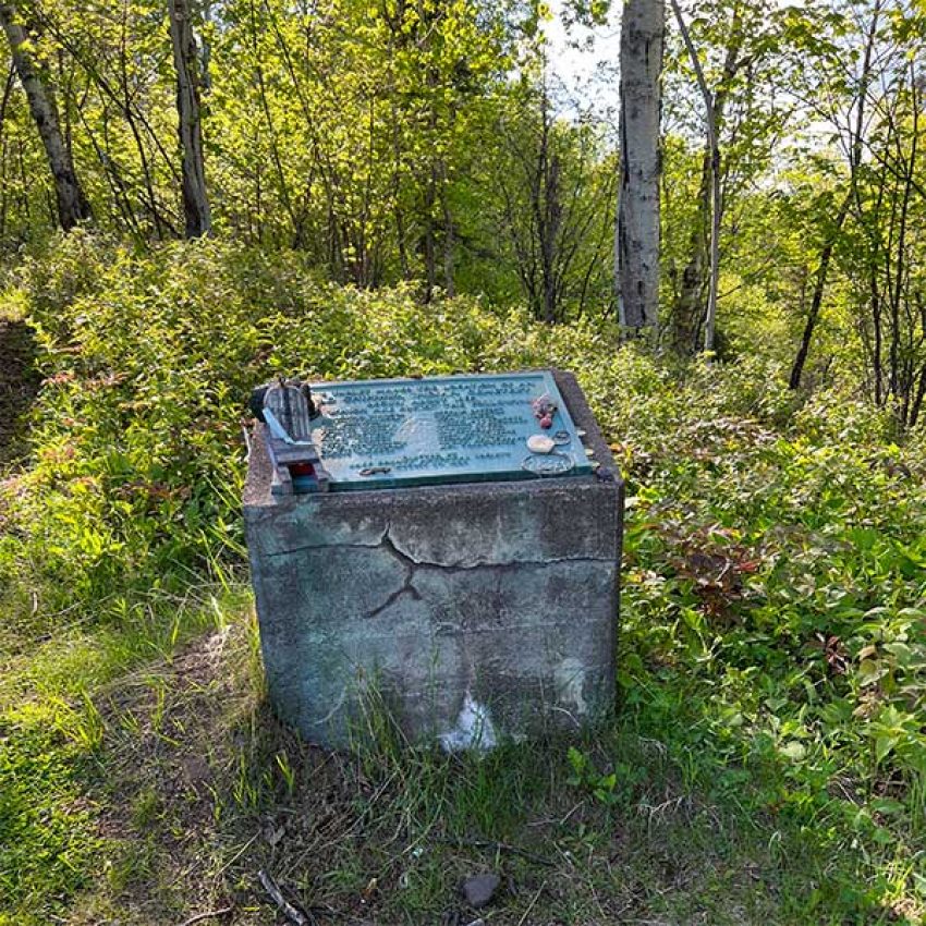 chief-john-beargrease-grave-marker concrete grave marker of chief john beargrease set in the woods