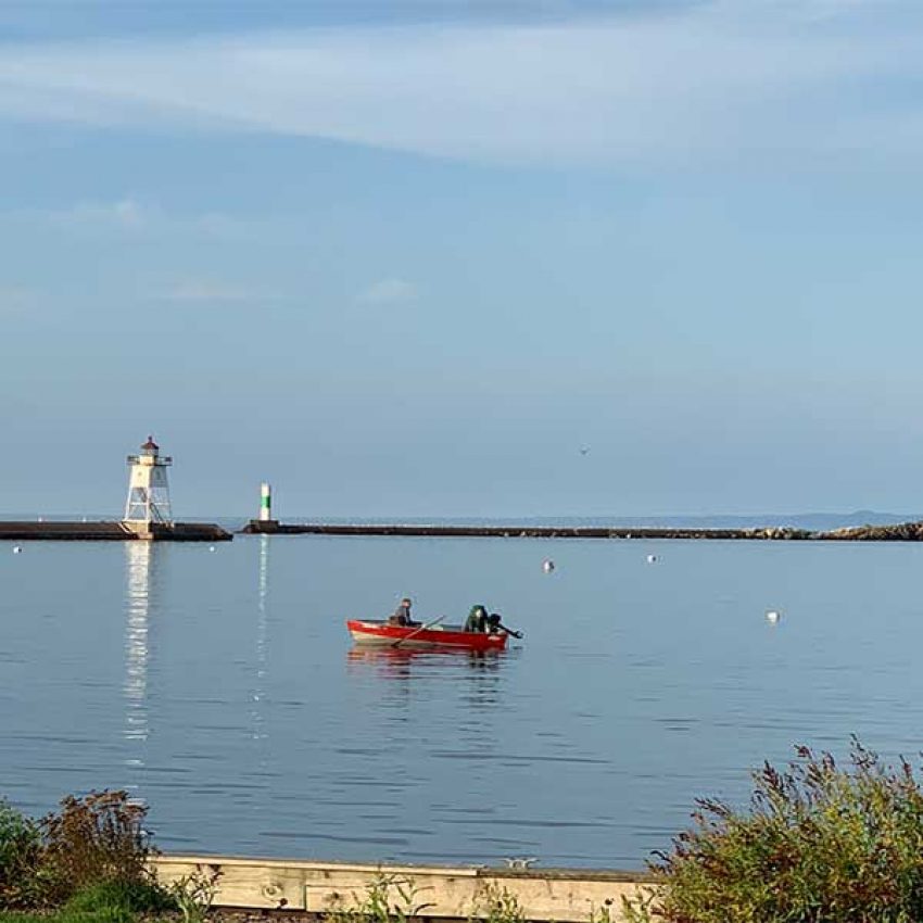 grand-marais-sum-sq two men in a red and silver fishing boat in the grand marais mnm harbor