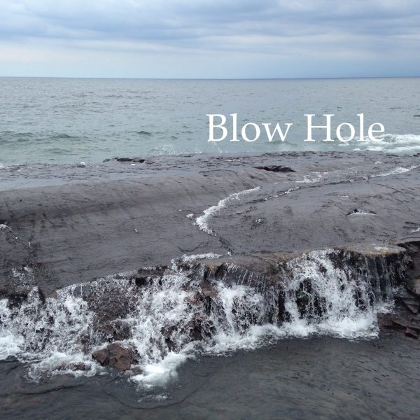 lake superior waves roll over rock with blow hole