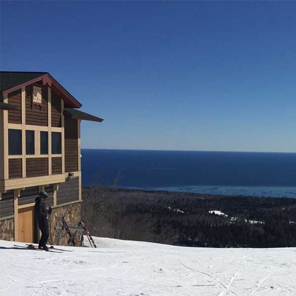skier at summit chalet looking at lake superior
